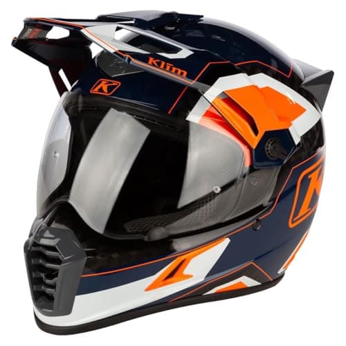 Adventure motorcycle rider in a peaked helmet on a mountain trail